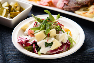Vegetable salad and cheese on a white plate
