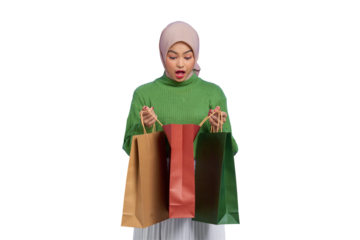 Shocked beautiful Asian woman in green sweater opening shopping bags isolated on transparent background