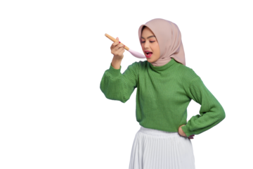 Beautiful Asian woman in green sweater and hijab holding a spoon, want to taste delicious food isolated on transparent background