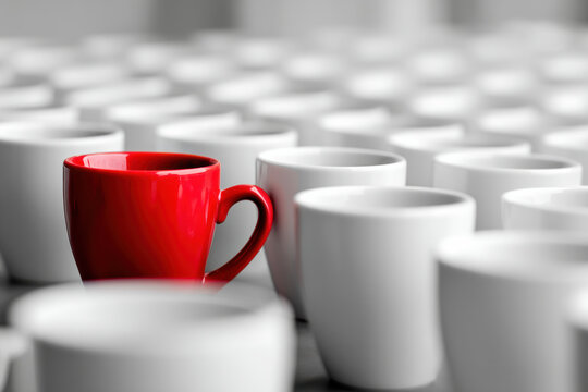 a large group of coffee cups placed in a pattern with one red cup standing out