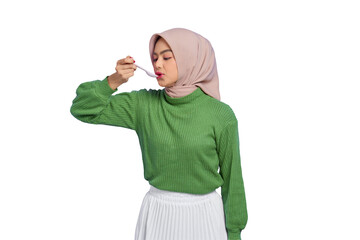 Beautiful young Asian woman in green sweater licking spoon eating delicious meal dish isolated on...