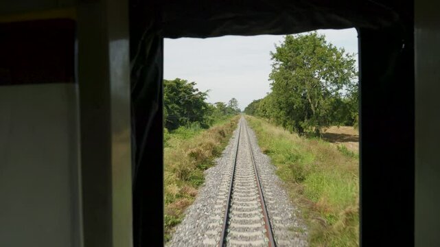 POV shot from train of Thailand's Eastern Line from Bangkok to Ban Klong Luk during the day in Thailand, medium shot