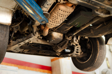 Low angle view of leveraged car engine under inspection at workshop