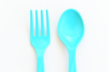 blue spoon and fork isolated on white background, plastic cutlery for picnic