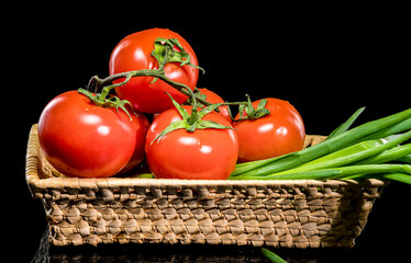 Fresh Tomatoes in Basket with Green Onions on Black Background