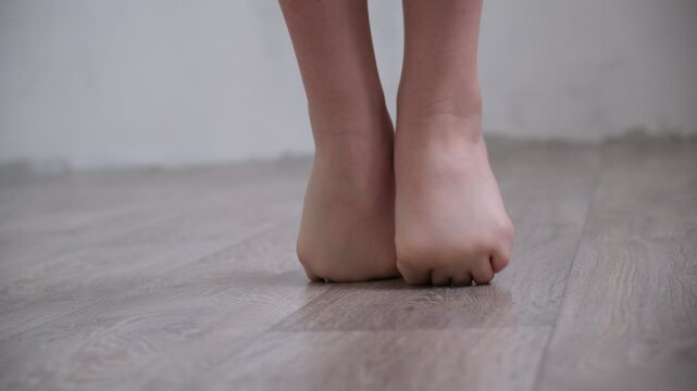 Barefoot teenage girl, dancer artist standing on tiptoe. Low section. Dance studio, tiptoe legs, position, practicing in ballet studio. Contemporary