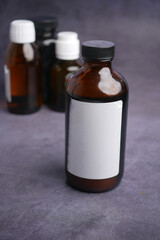  medicine glass bottle with blank label on a textured surface