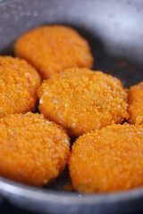Crispy golden nuggets frying in a skillet on the stove