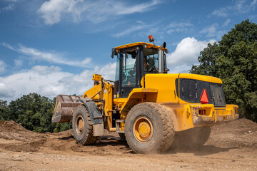Wheeled loader moving construction materials like gravel and earth on highway construction site