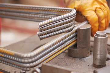 Metal bending process in construction site workshop during daytime