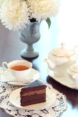 a slice of chocolate cake with a cup of tea