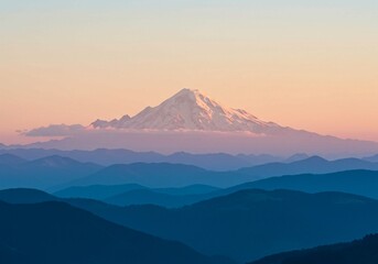 Naklejka premium The image shows a majestic snow-capped mountain peak dominating a tranquil panoramic vista of layered blue hazy ranges under a soft pastel sunrise or sunset sky