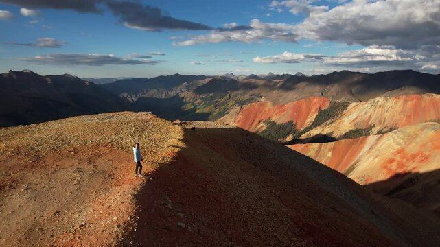 Drone Shot of Woman Walking on View Point Above Red Mountain Peaks, Colorado USA on Sunny Day