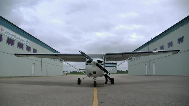 Male Pilot Checks Airplane Lights during External Preflight at Airport