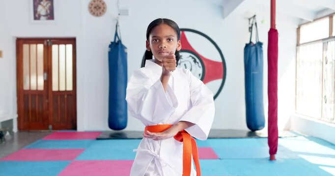 Girl, karate and ready with orange belt for martial arts training, self defense or fighting competition. Portrait, teenager or fighter preparation with strap or fist for taekwondo challenge in dojo