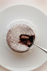 Fototapeta premium Looking down on chocolate soufflé broken with spoon