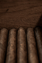 Rolled cigars stacked in wood box vertical