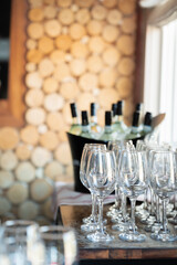 Empty wine glasses beside chilled bottles on a rustic wooden counter