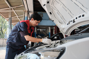 EV car check, Asian male mechanic worker inspects and maintains service of electric engine and...