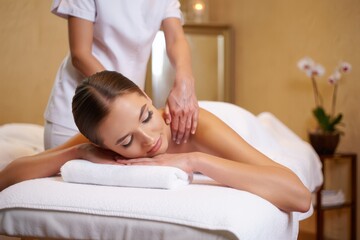 Young woman enjoying relaxing remedial body massage done by professional masseur