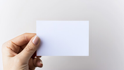 Fototapeta premium Hand holding blank paper card on neutral background