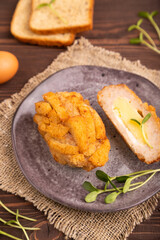 Chicken Schnitzel on gray plate with microgreen on brown wooden background and linen textile. side view, selective focus