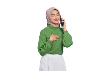 Portrait of smiling beautiful Asian woman in green sweater and hijab talking on mobile phone with hand on chest isolated on transparent background