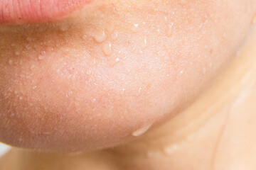 Close-up of a woman's face sweating in the hot summer