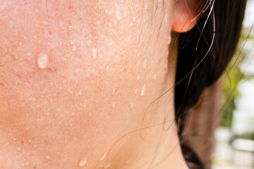 Close-up of a woman's face sweating in the hot summer