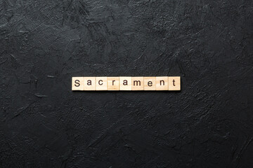 sacrament word written on wood block. sacrament text on table, concept