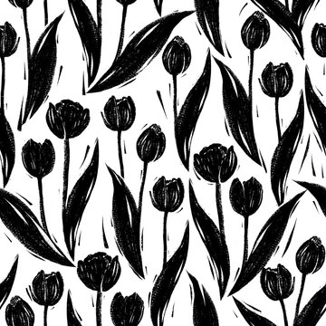 Seamless pattern with tulips in linocut technique with black paint on a white background