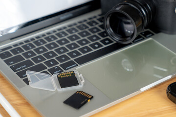 Freelance life, a happy young photographer copying photos from camera to laptop
