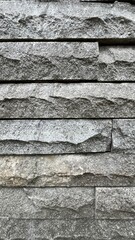 Textured gray stone wall background. Natural building material with rough surface pattern, suitable for architecture, construction, and design. 