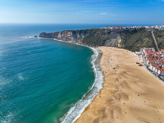 Aerial view of Nazare's expansive beach, port, and Atlantic horizon
