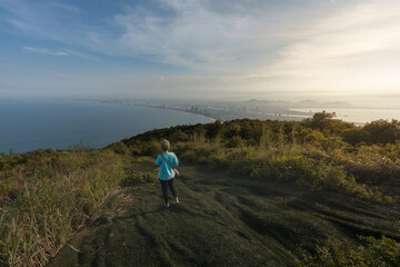 Solo female traveler walking at the scenic Ban Co Peak enjoying the panoramic view of Da Nang city in central Vietnam
