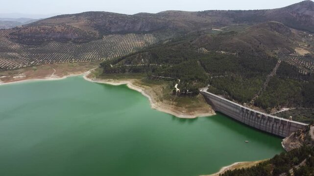 Panoramic aerial view of Iznajar Reservoir. The largest reservoir in Andalusia and the second largest in Spain in terms of extension. Beautiful travel destination. Drone panning left. 