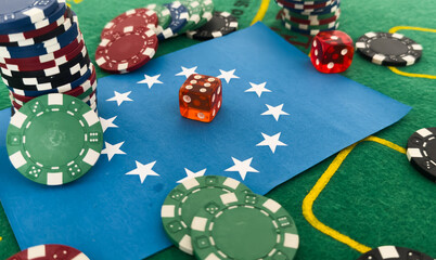 A set of poker chips stack on a green game table with a dice rolls. European Union flag. risk concept - playing poker in casino. Poker game theme. Red casino dice rolls.