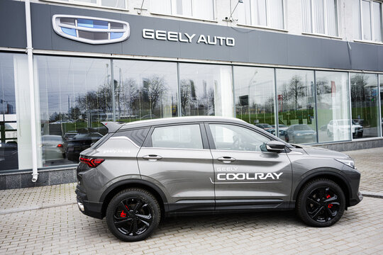 Side View of Geely Coolray SUV in Front of Auto Dealership Building