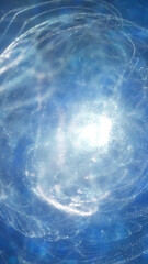 Abstract spiral burst of light and particles swirling in deep blue space, evoking a sense of cosmic energy and dynamic motion