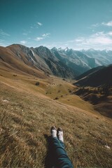 Fototapeta premium Scenic mountain landscape with a person relaxing on the grass, surrounded by majestic peaks and valleys