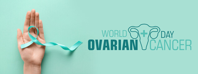 Female hand with light blue ribbon on turquoise background. World Cancer Day