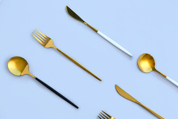 Golden cutlery on blue background