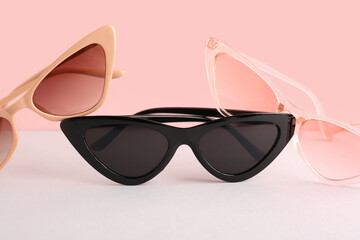 Stylish sunglasses on color background