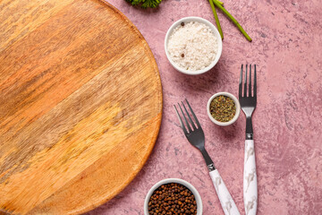 Composition with wooden cutting board and fresh spices on color background, closeup