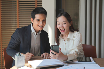 excited business people watching on mobile phone read a good news