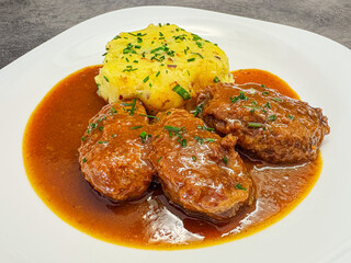 Roasted pork cheeks with thick dark vegetable sauce and mashed potatoes