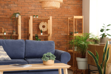 Beautiful interior of loft style living room with shelving units, table, sofa and houseplants