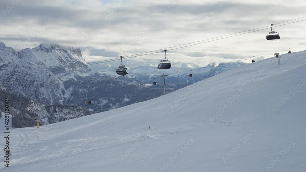 Poster ski gondolas glide up a pristine slope with rugged mountains stretching across the horizon. parallax