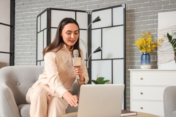 Female reporter with microphone and laptop in studio