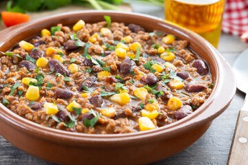 Traditional Mexican Chili con carne. Minced meat and vegetables stew in tomato sauce on wooden table. Close up